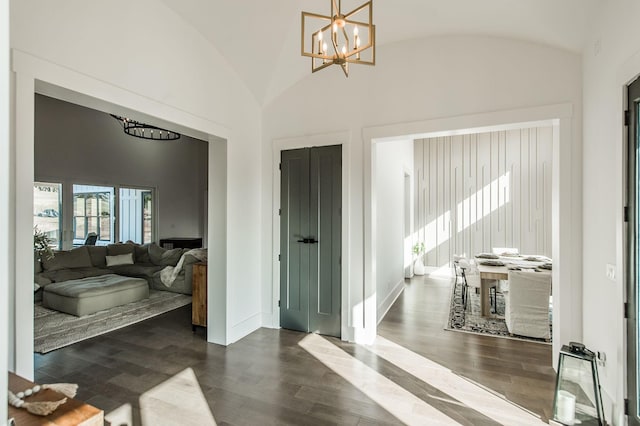 foyer entrance with a notable chandelier, vaulted ceiling, and dark hardwood / wood-style floors