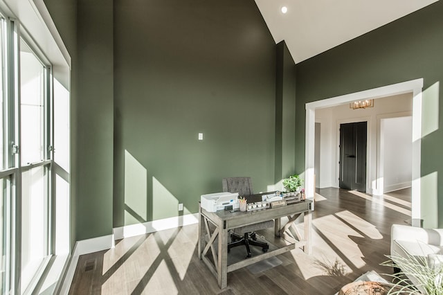 office space with a notable chandelier and high vaulted ceiling