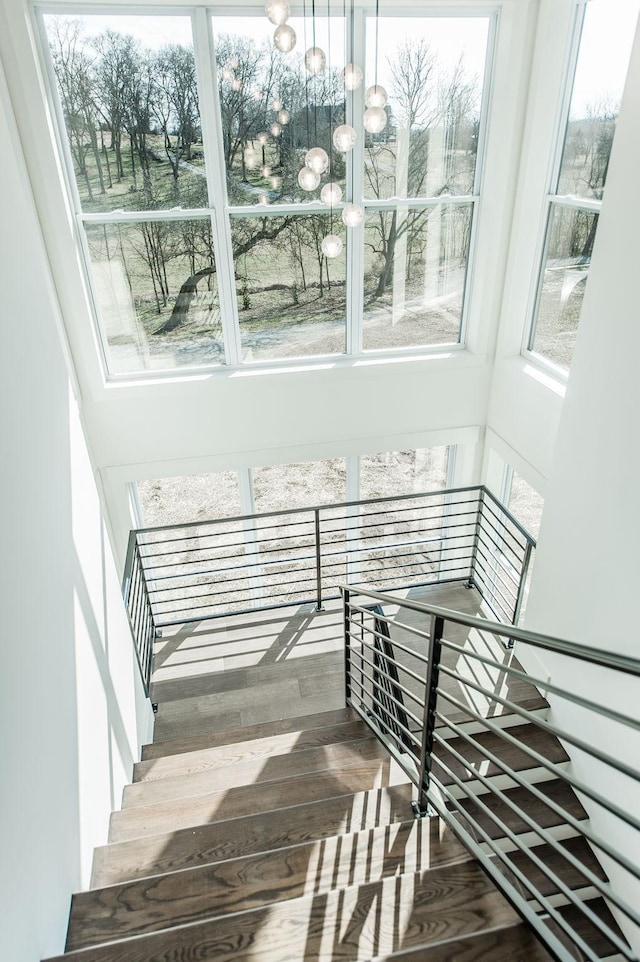 staircase featuring wood-type flooring and a chandelier