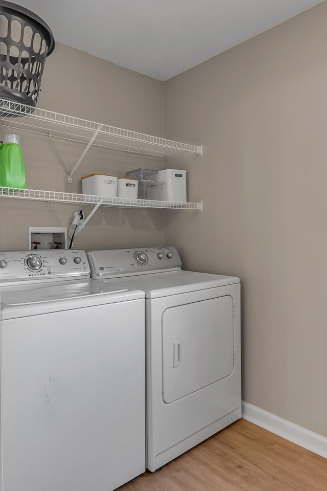 laundry room with independent washer and dryer and light wood-type flooring