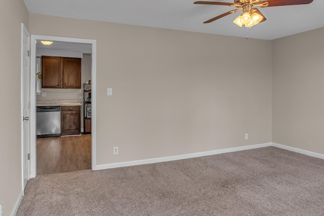 carpeted spare room featuring ceiling fan