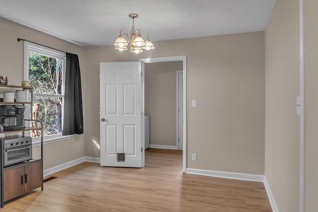 interior space featuring light wood-type flooring and a notable chandelier