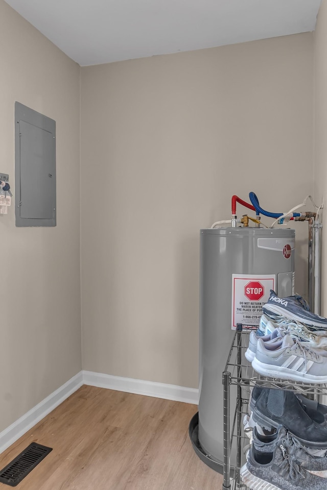 utility room featuring electric water heater and electric panel