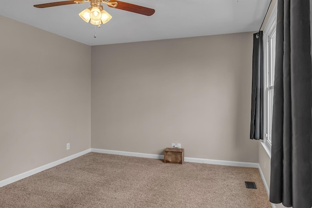 spare room with ceiling fan and carpet