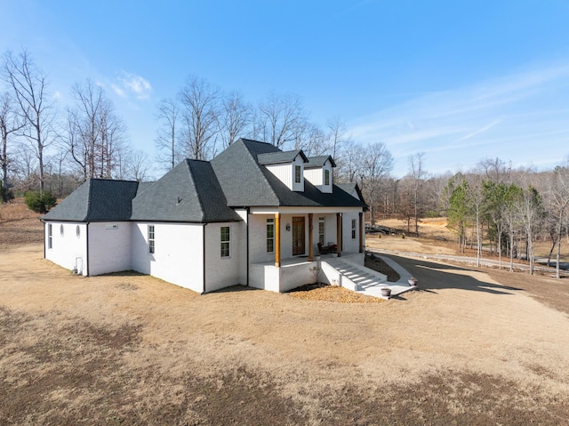 exterior space featuring a porch and a lawn