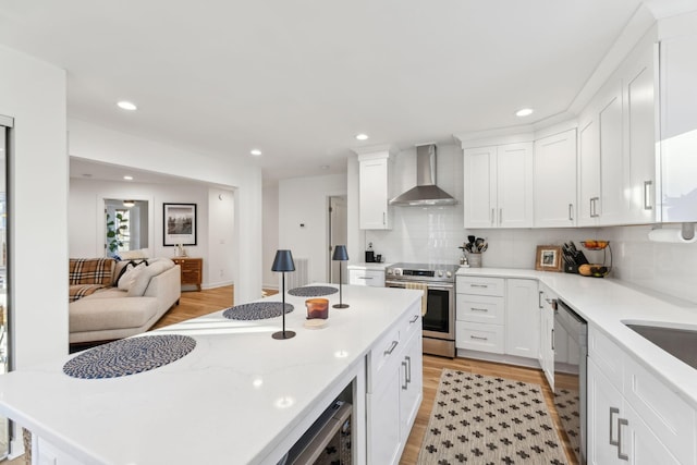 kitchen featuring stainless steel range with electric stovetop, white cabinetry, backsplash, and wall chimney exhaust hood