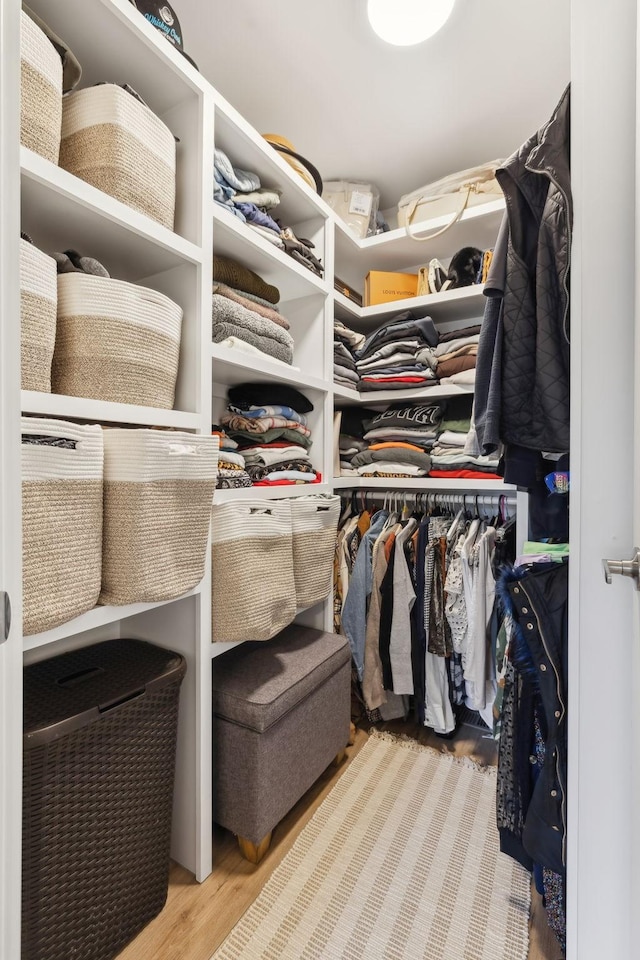 walk in closet with light hardwood / wood-style flooring