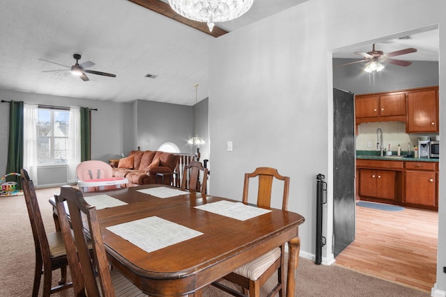 carpeted dining room with a chandelier and sink