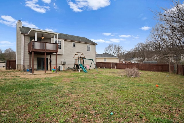 back of house featuring cooling unit, a playground, and a lawn