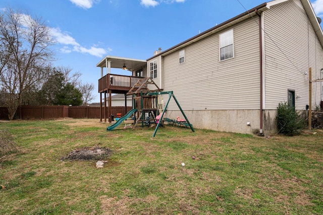 rear view of house featuring a yard and a playground