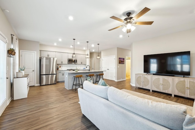 living room with wood-type flooring and ceiling fan