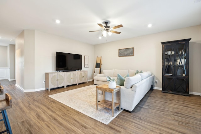 living room featuring wood-type flooring and ceiling fan