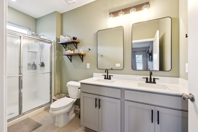 bathroom with vanity, a shower with door, tile patterned flooring, and toilet