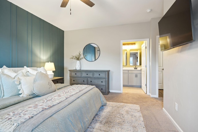 bedroom featuring connected bathroom, ceiling fan, and light colored carpet