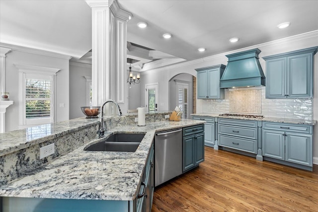 kitchen featuring sink, custom range hood, blue cabinetry, and appliances with stainless steel finishes