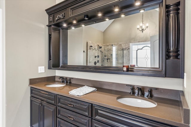 bathroom featuring a shower with door, vaulted ceiling, a chandelier, and vanity