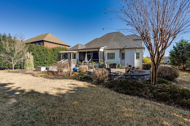 rear view of property with a patio, a sunroom, and a lawn