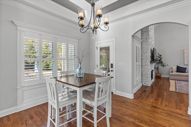 dining area with dark hardwood / wood-style flooring, crown molding, and a chandelier