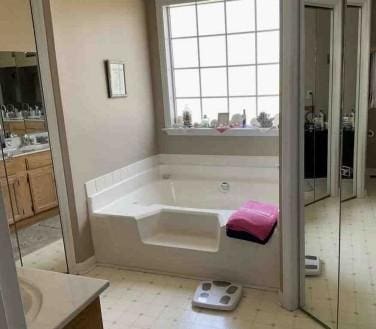 bathroom with a washtub and vanity