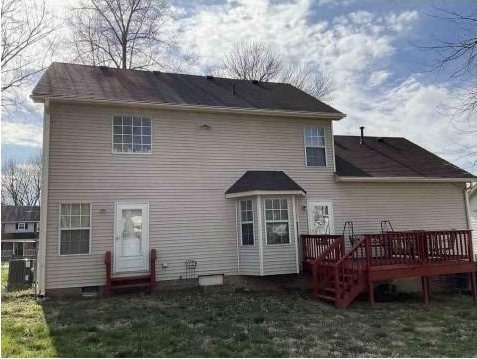 rear view of property with cooling unit, a deck, and a yard