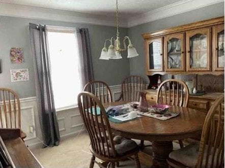 dining space featuring a notable chandelier, crown molding, and plenty of natural light