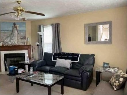 living room with a textured ceiling and ceiling fan