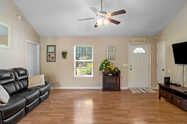 living room with ceiling fan, vaulted ceiling, and light hardwood / wood-style flooring