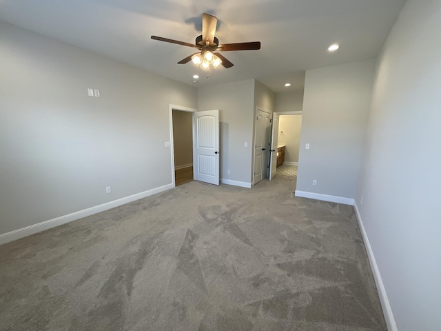 unfurnished bedroom featuring ensuite bathroom, ceiling fan, and light colored carpet