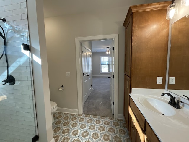 bathroom featuring toilet, walk in shower, and vanity