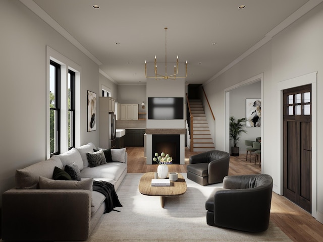 living room with a notable chandelier, light hardwood / wood-style flooring, and ornamental molding