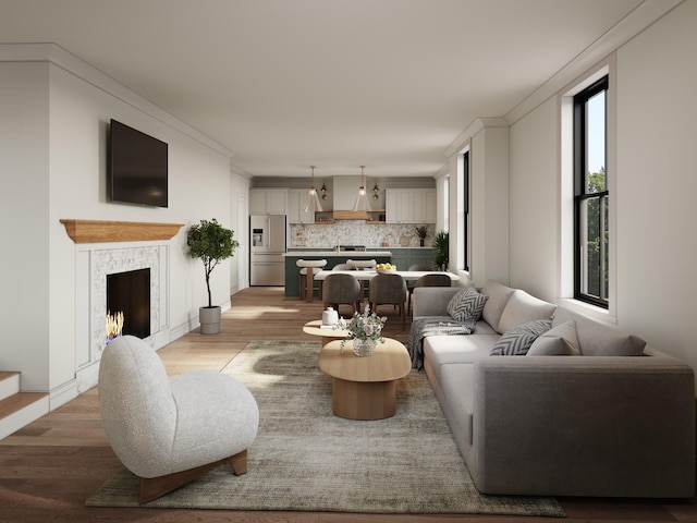 living room featuring light hardwood / wood-style flooring, crown molding, and a fireplace