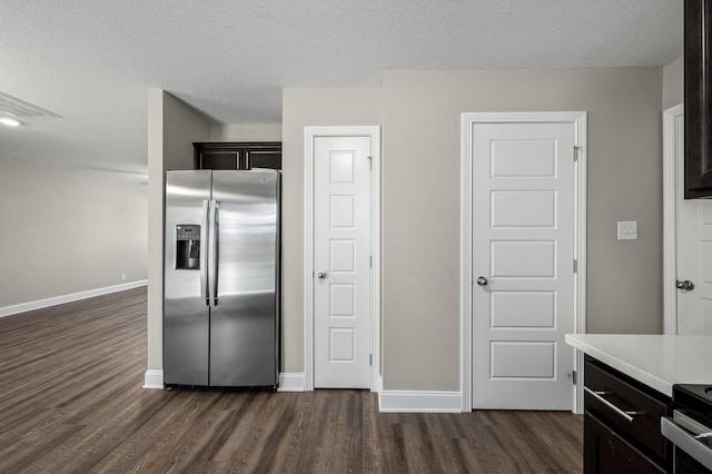 kitchen with electric range, a textured ceiling, dark hardwood / wood-style floors, and stainless steel fridge