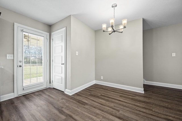 unfurnished dining area featuring an inviting chandelier and dark hardwood / wood-style floors