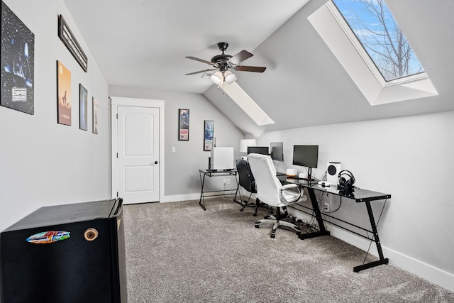 carpeted office space featuring ceiling fan and vaulted ceiling with skylight