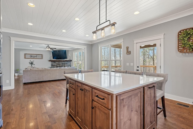 kitchen featuring a kitchen breakfast bar, wood ceiling, dark hardwood / wood-style flooring, pendant lighting, and a kitchen island