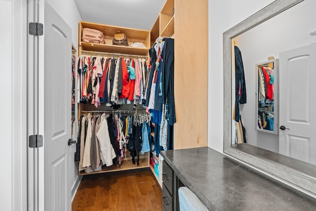 walk in closet with dark hardwood / wood-style floors