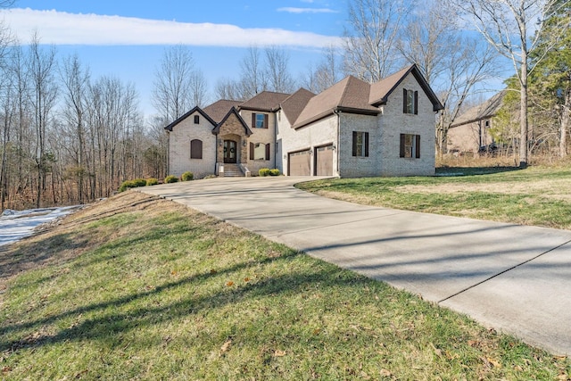 french country style house featuring a front yard and a garage