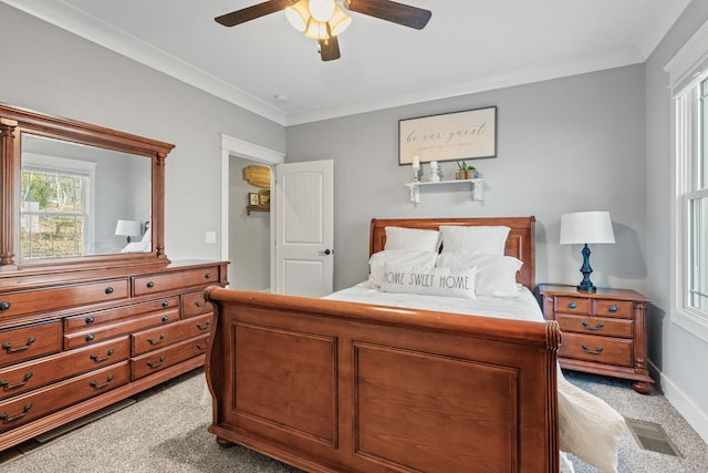 bedroom with ceiling fan, crown molding, and light colored carpet