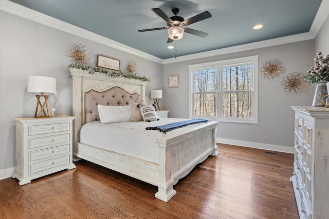 bedroom featuring ceiling fan, crown molding, and dark wood-type flooring