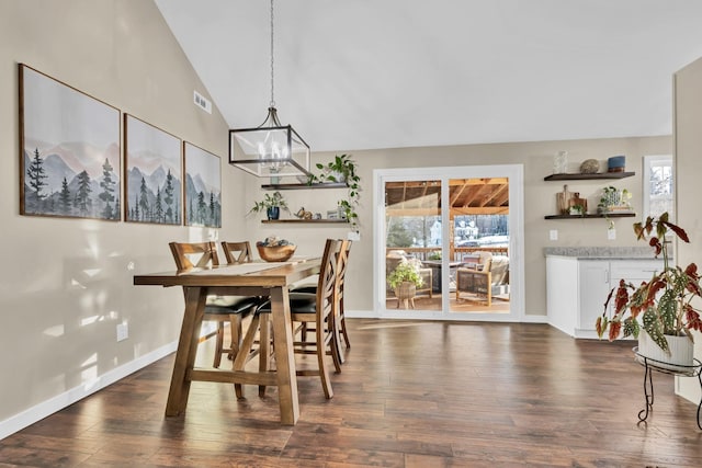 dining room featuring dark hardwood / wood-style flooring, an inviting chandelier, and vaulted ceiling