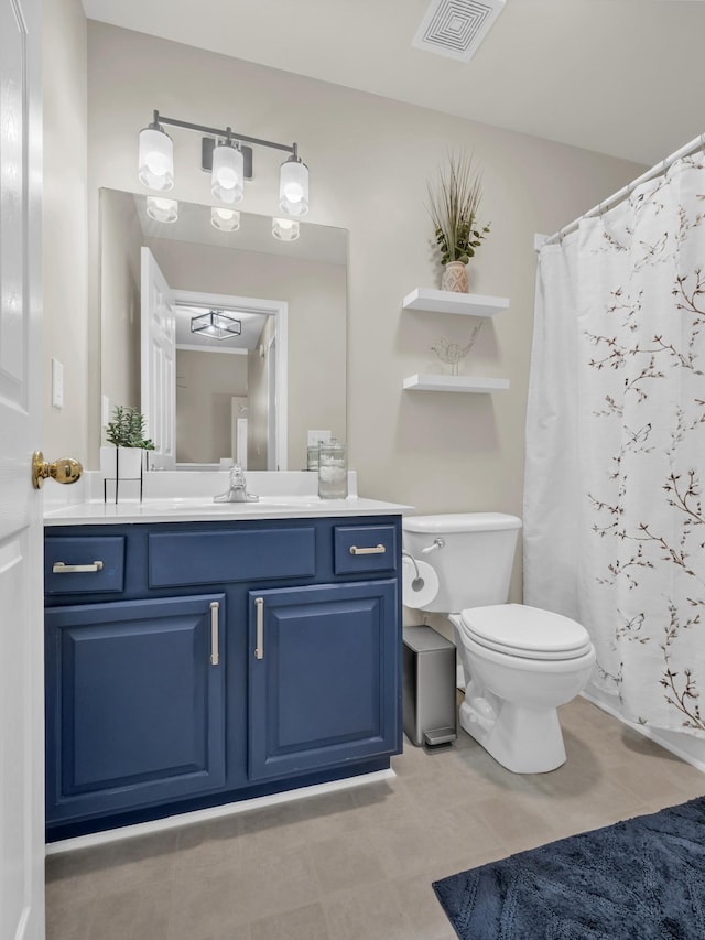 bathroom featuring walk in shower, tile patterned floors, vanity, and toilet