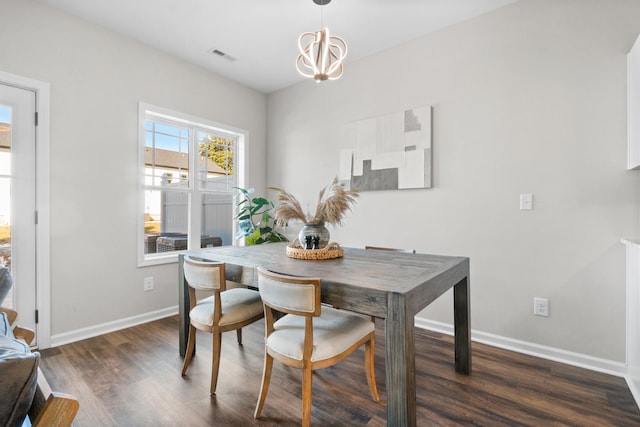 dining area featuring dark hardwood / wood-style flooring and an inviting chandelier