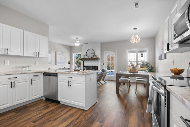 kitchen with white cabinetry, stainless steel appliances, kitchen peninsula, and hanging light fixtures