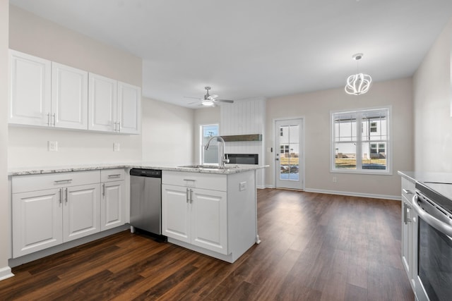 kitchen featuring white cabinets, kitchen peninsula, appliances with stainless steel finishes, and sink