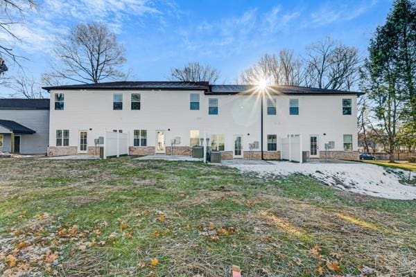 back of property with a patio area, central AC, and a lawn