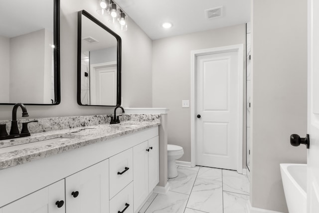 bathroom featuring a tub to relax in, vanity, and toilet