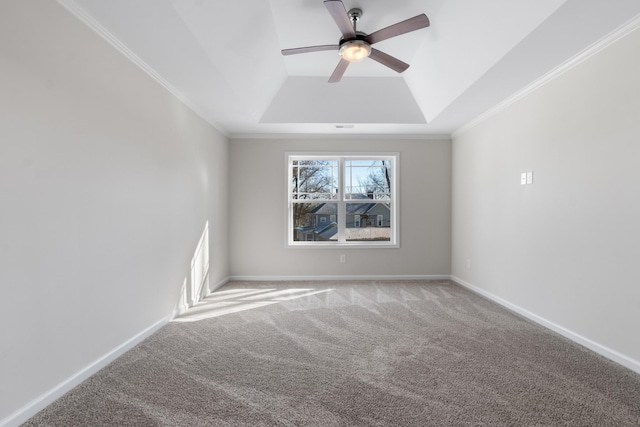 carpeted spare room with ceiling fan, crown molding, and a raised ceiling