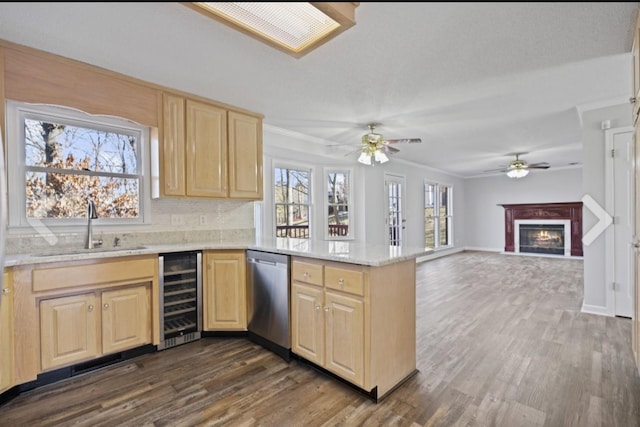 kitchen featuring sink, a fireplace, kitchen peninsula, stainless steel dishwasher, and wine cooler