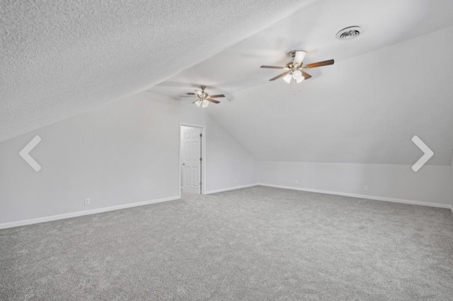 bonus room featuring ceiling fan, vaulted ceiling, carpet floors, and a textured ceiling