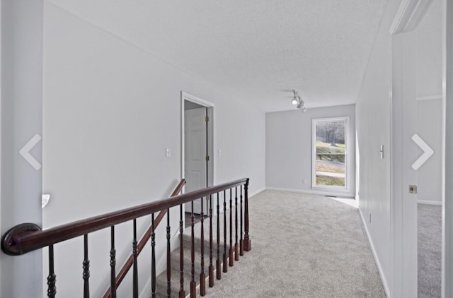 hall featuring a textured ceiling and carpet